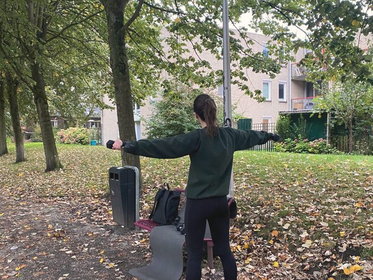 Iemand traint met een weerstandsband in een park in de herfst