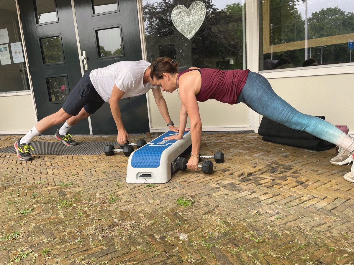 Twee mensen trainen op de stoep voor een voordeur met opstapjes